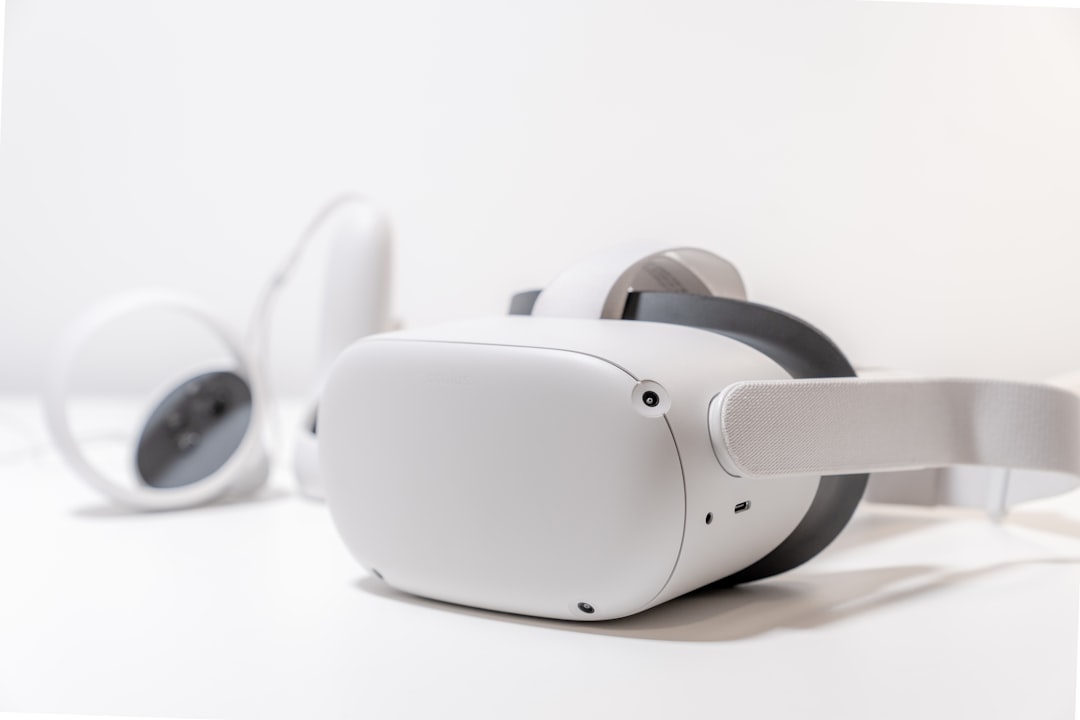 Un casque de réalité virtuelle blanc et ses manettes posés sur une table claire